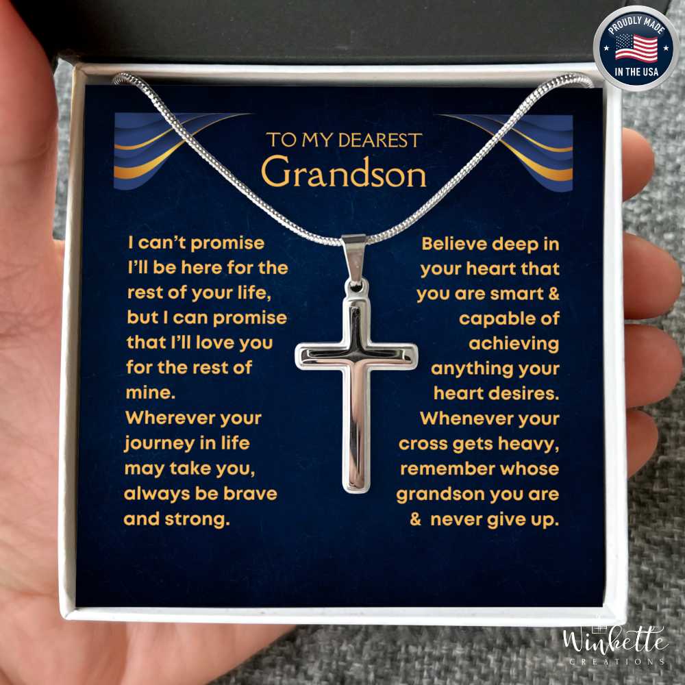 Silver cross necklace in a gift box with a message to a grandson, held by a hand. Gift for grandson from grandma grandpa