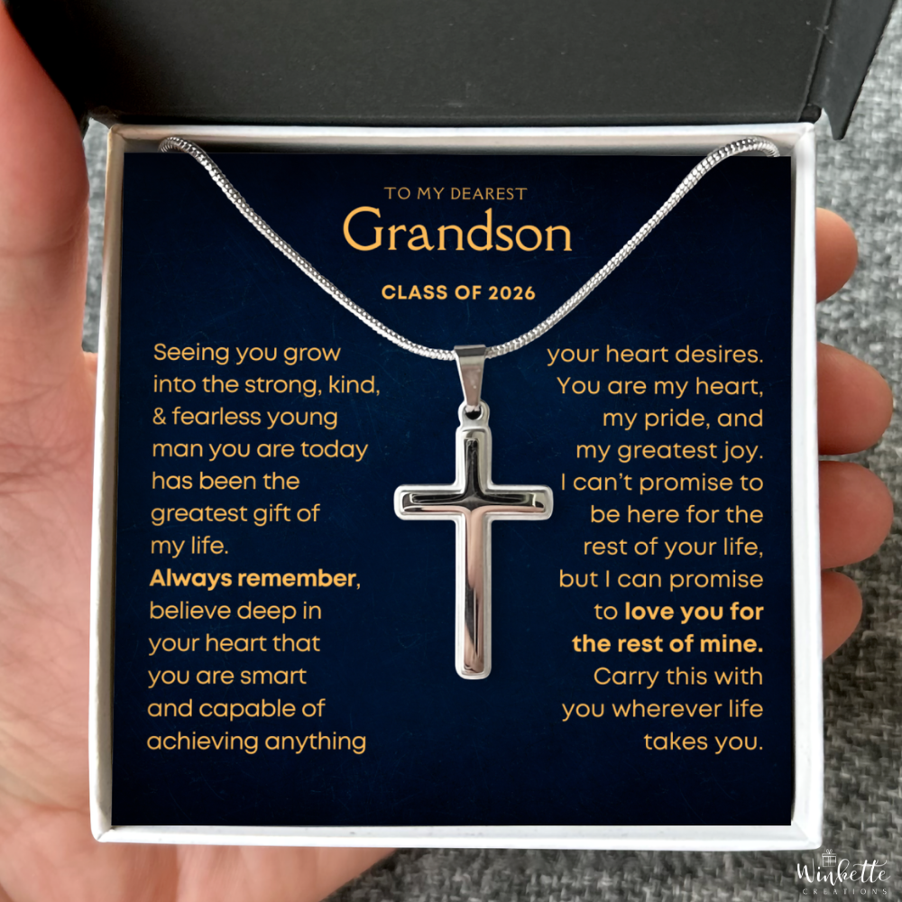 Silver cross necklace in a gift box with a message to a grandson, held by a hand. Gift for grandson from grandma grandpa.