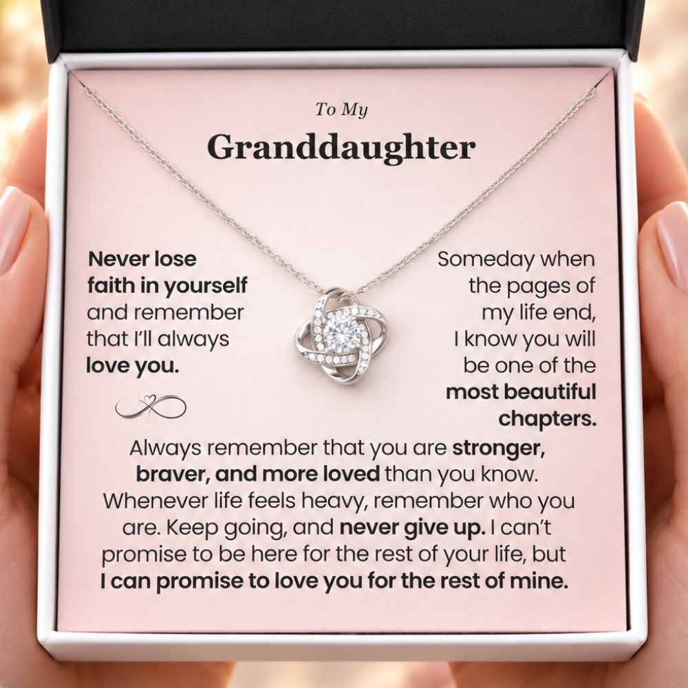 Hands holding a classic white jewelry box with a silver Love Knot necklace and pink “To My Granddaughter” message card, sentimental granddaughter gift from grandma.
