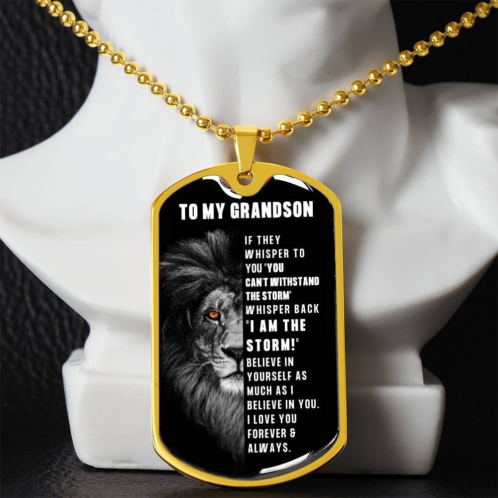 A luxury dog tag gold necklace with a black and white image of a lion's face on the tag, and text on the tag that reads 'TO MY GRANDSON. You are the storm.