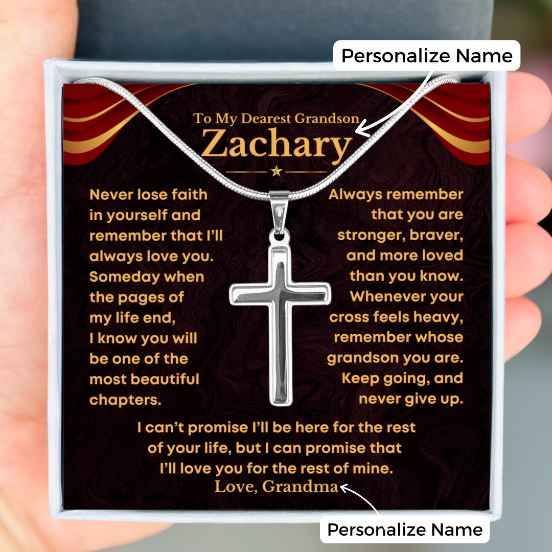 A silver cross necklace on a snake chain presented in gift box with a personalized message for a grandson from grandma