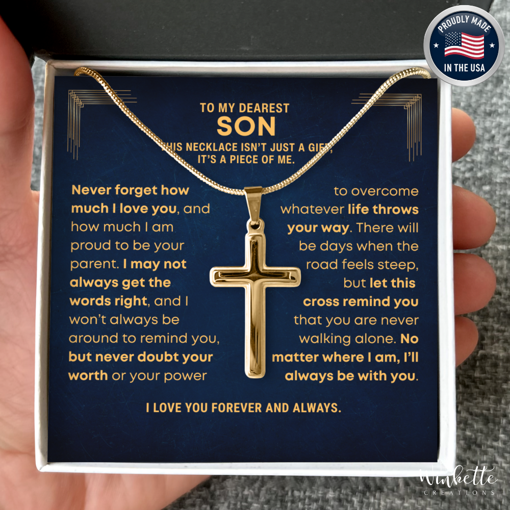 Gold cross necklace in a box with sentimental message, held by a hand. Gift for son from mom dad