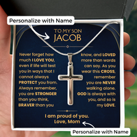 Thumbnail for A silver cross pendant necklace displayed on a personalized dark blue gift card inside a white box, held by a hand. The card features gold text with a message for 'my son Jacob' and white 'Personalize with Name' labels.