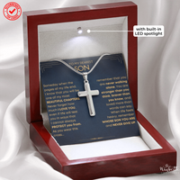 Thumbnail for A silver cross necklace displayed inside a wooden keepsake box with a built-in LED spotlight and printed message card. The box is set against a soft white draped fabric background.