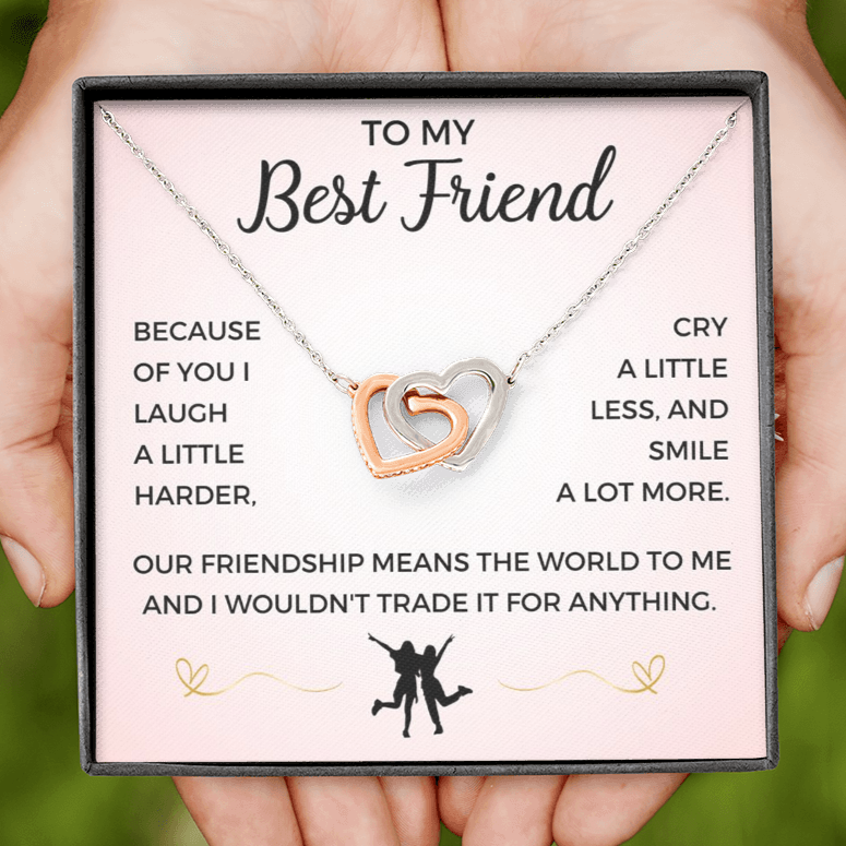A friendship necklace with two intertwined hearts, one heart adorned with cubic zirconia crystals, presented in a box with a message card.