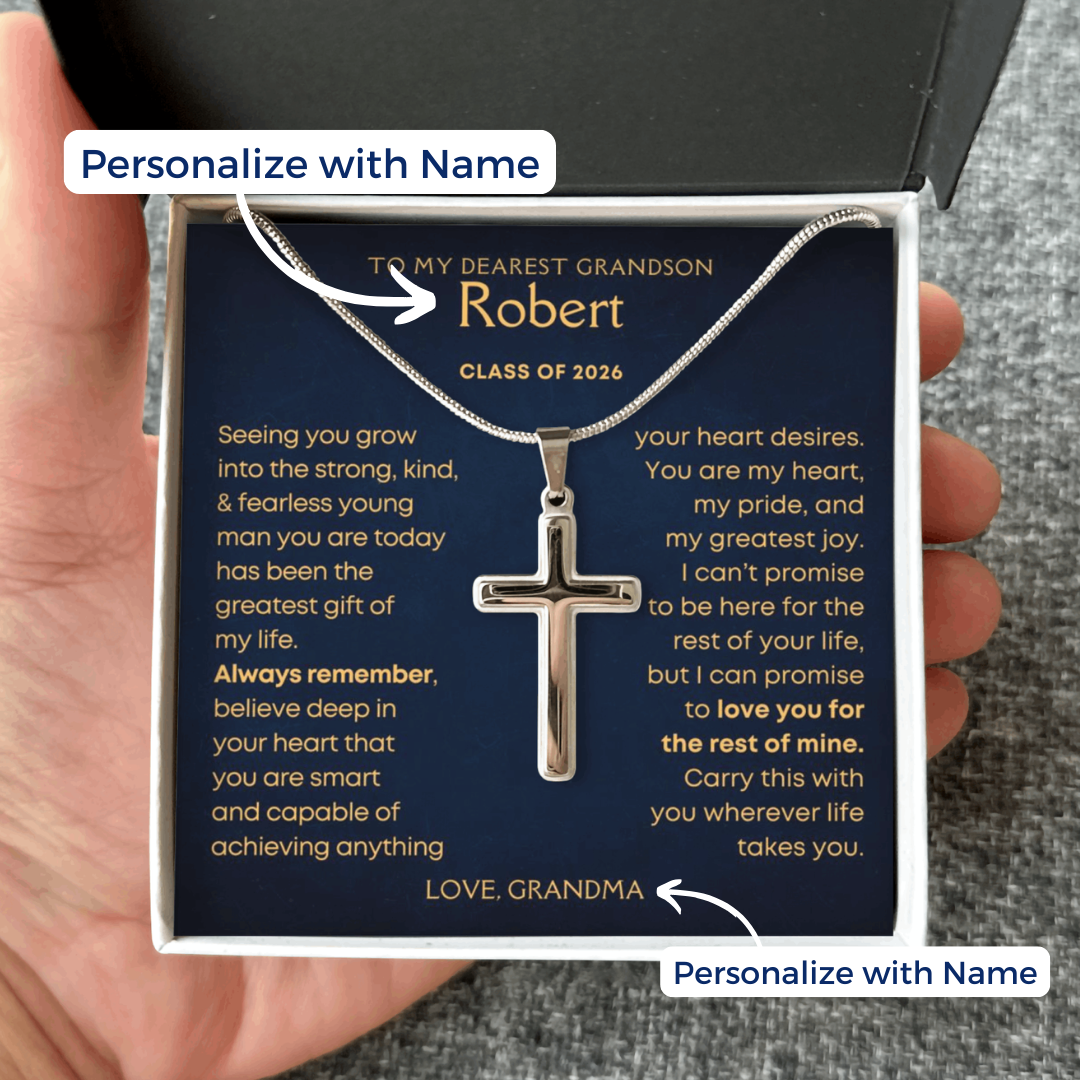Silver cross necklace in a gift box with a personalized message card to a grandson, held by a hand. Graduation Gift for grandson from grandma grandpa.
