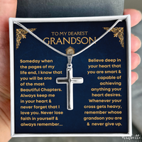 Thumbnail for A silver cross pendant necklace presented in a gift box with a dark blue message card addressed to a grandson. A hand is holding the box open, and the necklace is displayed against the card.