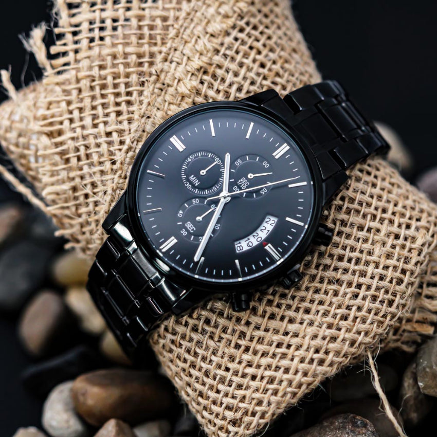 Black wristwatch with detailed face on a textured fabric background