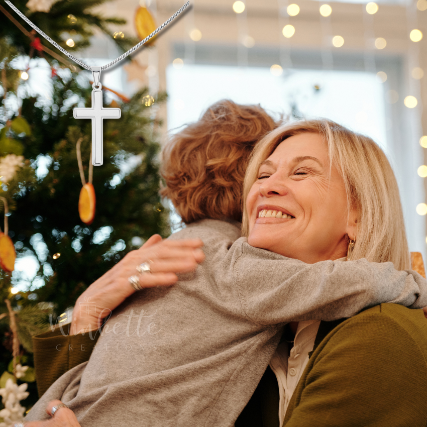 Grandson and Grandma hugging in front of a decorated Christmas tree with lights in the background.