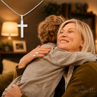 Thumbnail for Grandma and grandson hugging with a cross necklace in the foreground, set against a blurred indoor background.