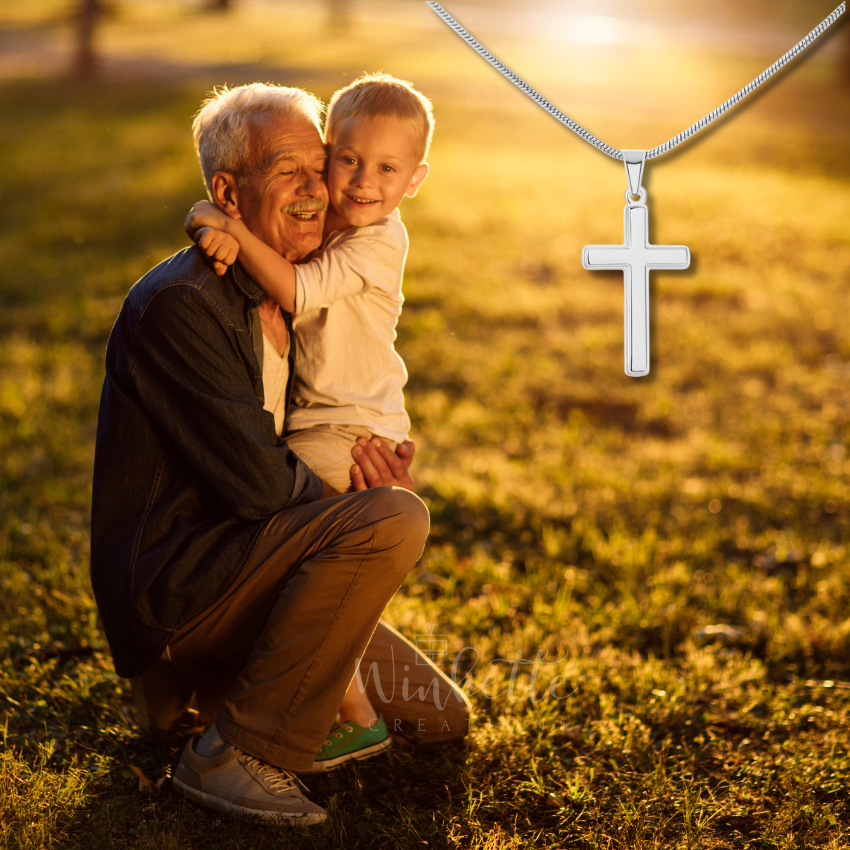 Grandfather holding his grandson with a cross necklace in the foreground