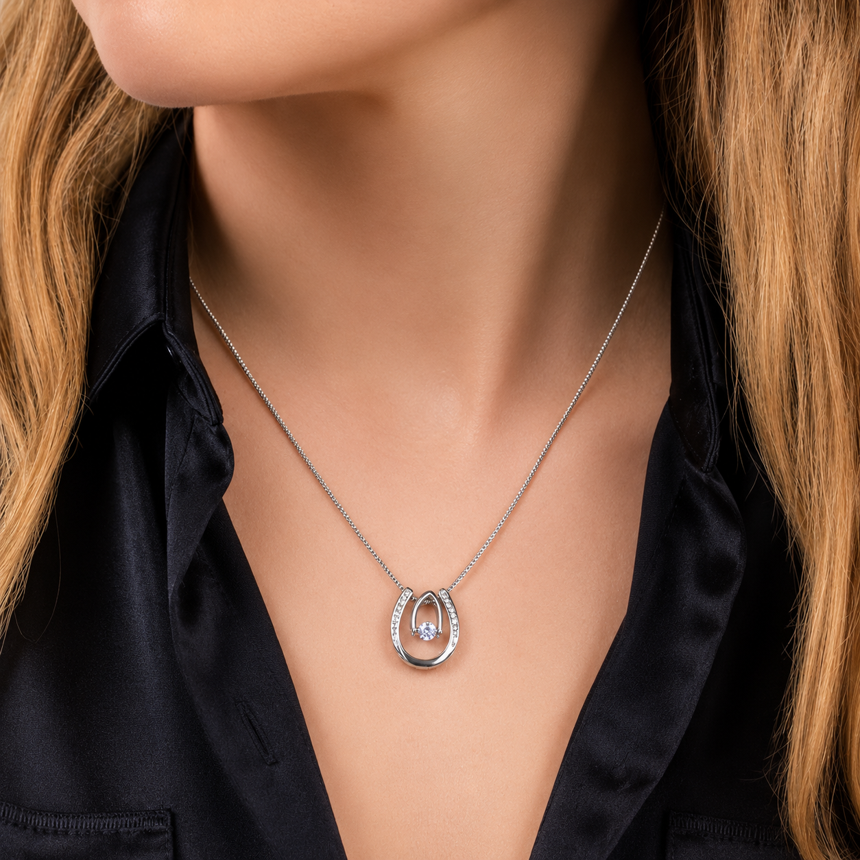 Woman wearing personalized lucky horseshoe necklace for granddaughter featuring a sparkling pendant and elegant silver chain styled with a black satin blouse