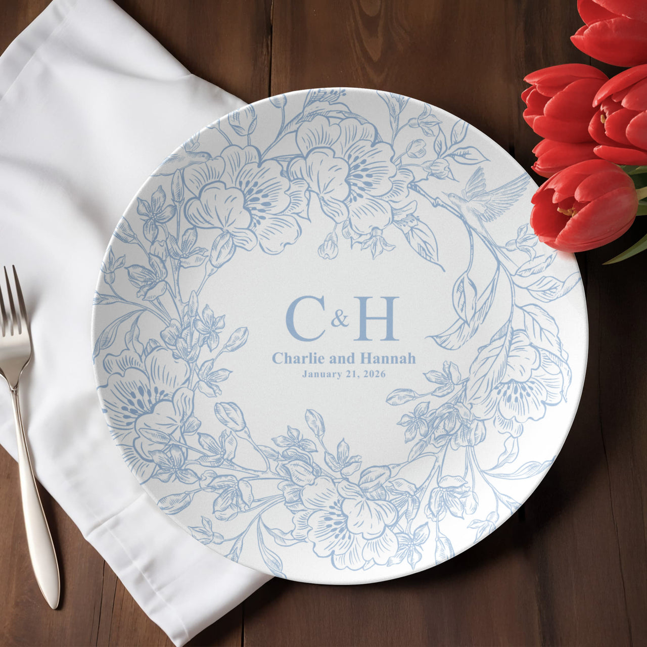 Round polymer plate with decorative pattern on a wooden table with a white napkin and red tulips.