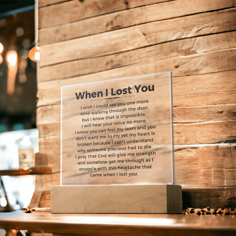 Acrylic plaque with a poem titled 'When I Lost You' on a wooden stand against a wooden wall. Memorial gift