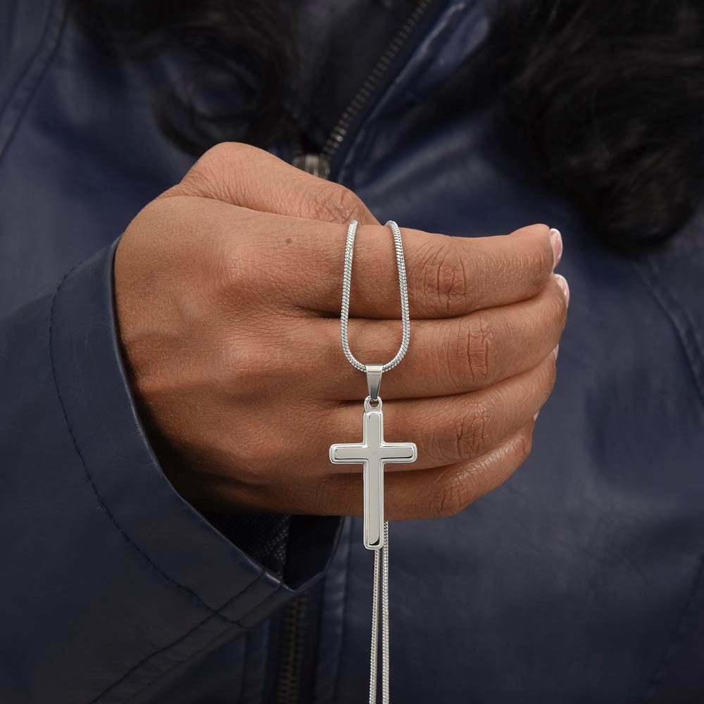A hand held silver cross necklace for grandson.