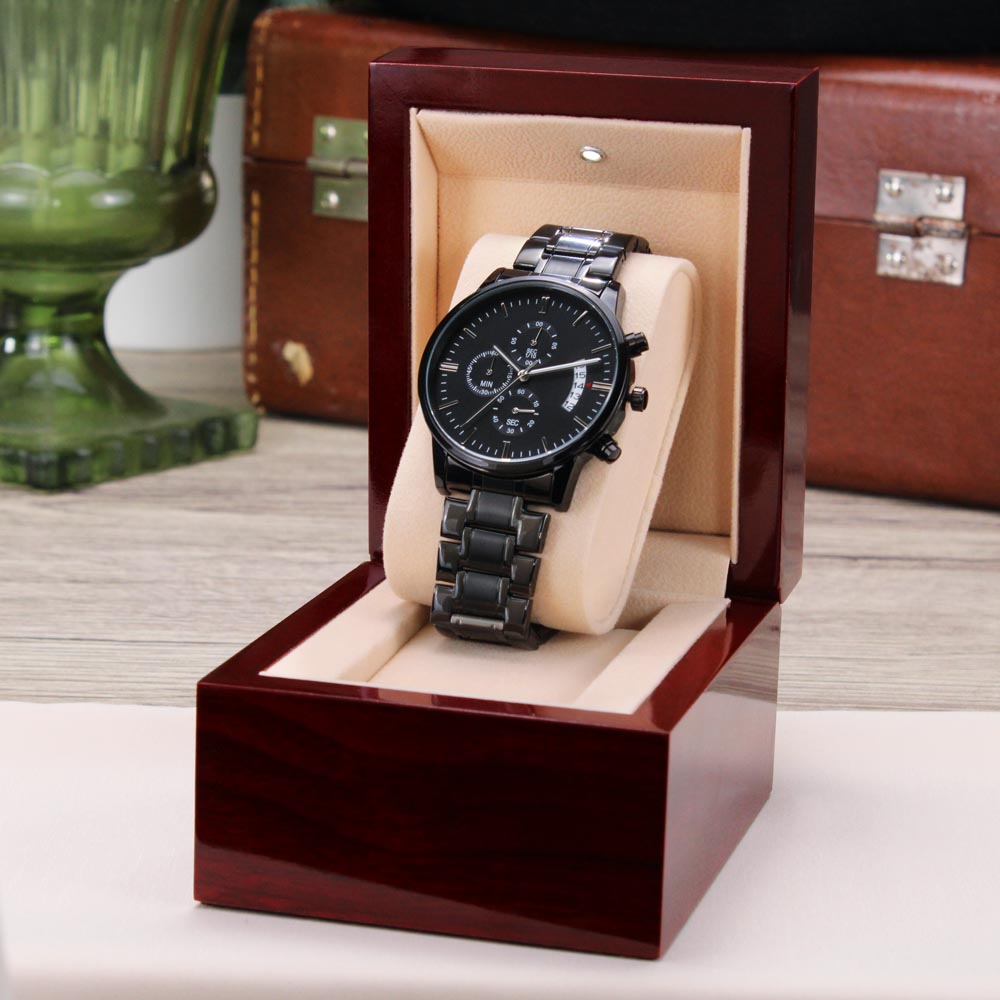 A black chronograph wristwatch with an engraved heartfelt message to grandson in a luxury box